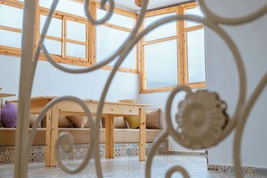 A room with a wooden table, a sofa, and a patterned floor.