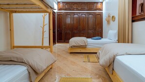 A room with bunk beds, a wardrobe, and a skylight.