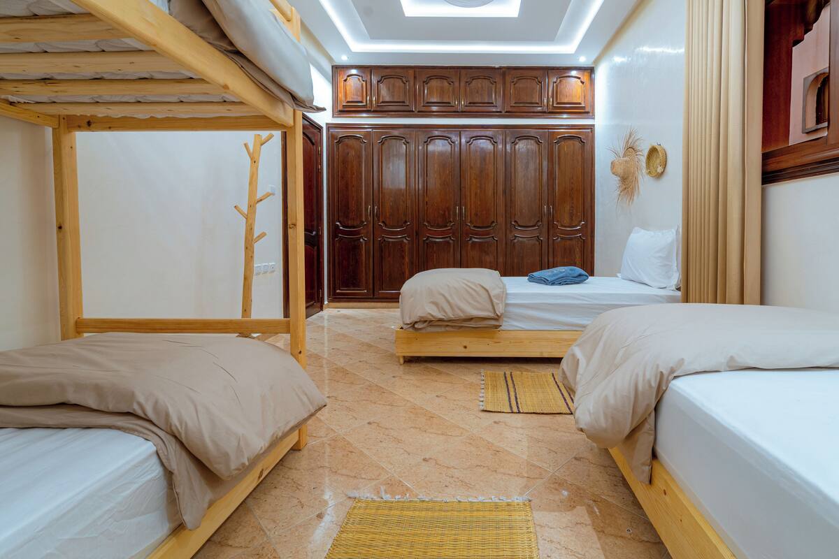 A room with bunk beds, a wardrobe, and a skylight.