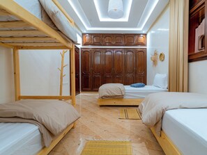 A room with bunk beds, a wardrobe, and a skylight.