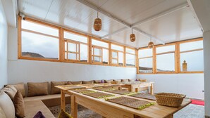 Una habitación con una mesa larga, varias ventanas y vistas al exterior.