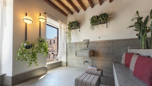 A modern interior with a stone floor, a bench, hanging plants, and a window with a view. - Ara di Marte Living Art (Rome)
