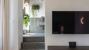 A staircase leading to a landing with a flat-screen TV mounted on the wall above a wooden cabinet. - Ara di Marte Living Art (Rome)