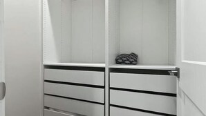 Un armario blanco con varios cajones y espacio para colgar.