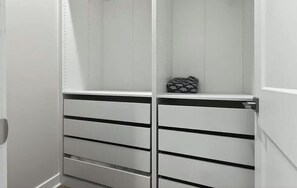 Un armario blanco con varios cajones y espacio para colgar.