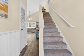 A staircase with carpeted steps leading to a landing. - "Better Together" 4 bed, 2.5 bath , sleeps 10 provides your home away from home. (Ocean Isle Beach)