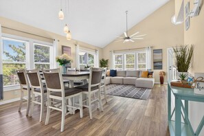 A spacious living area with a dining table, chairs, a sofa, and a ceiling fan. - "Better Together" 4 bed, 2.5 bath , sleeps 10 provides your home away from home. (Ocean Isle Beach)
