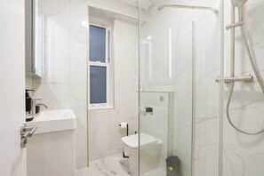 Ein modernes Badezimmer mit einer Duschkabine, einer Toilette und einem Waschbecken.