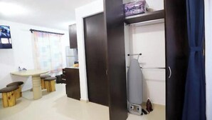A hotel room with a dining area, a wardrobe with a hanging iron, and a bed. - Spacious and quiet apartment PKG free of charge (San Miguel de Allende)