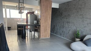 A modern living area with a kitchen, dining table, and a seating area. - Apartment on Praia do Futuro beach, 200m from the sea. (Fortaleza)