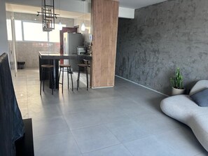 Ein moderner Wohnbereich mit Küche, Esstisch und einer Sitzecke.