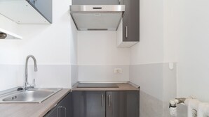 Een moderne keuken met roestvrijstalen apparatuur, een gootsteen en een inbouwoven.