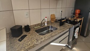 A kitchen with a granite countertop, stainless steel sink, and a built-in oven. - Comfortable 2-Bedroom AC Apartment  Prime Location for Corporate Travel (São José do Rio Preto)