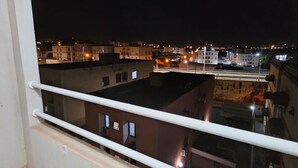 A nighttime view from a balcony with railings, overlooking a cityscape with buildings and a bridge. - Comfortable 2-Bedroom AC Apartment  Prime Location for Corporate Travel (São José do Rio Preto)