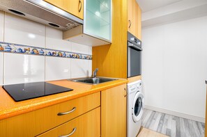 A kitchen with a built-in oven, a washing machine, and a sink. - Apartment 'Benidorm Poniente' with Communal Pool (Benidorm)