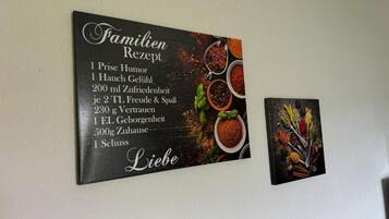 A wall-mounted sign with a family recipe list and a smaller picture of spices.