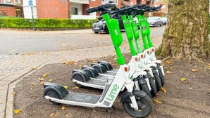 Een rij Lime elektrische scooters op een voetpad.