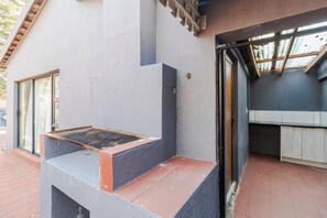 Ein modernes Gebäude mit einer Betonfassade, einem Fenster und einer Tür, die in einen Küchenbereich führt.