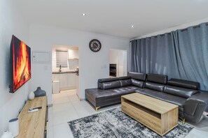 Ein modernes Wohnzimmer mit einer Ledersofa, einem Holztisch und einem Bild an der Wand.
