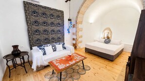 Una habitación acogedora con cama, una mesita pequeña, un tapiz decorativo y un techo abovedado único.