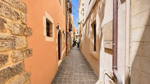 A narrow alley with stone walls and a cobblestone path. - Suite Victoria - Venetian Palace - Rooftop Jacuzzi (Chania)