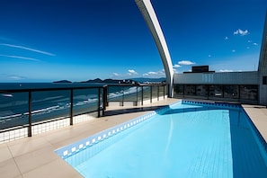 A modern rooftop pool with a clear view of the ocean and distant mountains. - SHB - Family 2 Suítes Piscina e Academia (Santos)
