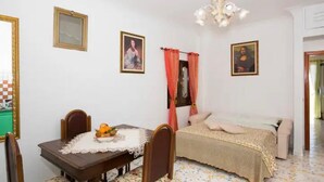 A room with a bed, a table with chairs, and two framed pictures on the wall. - Casa degli Dei, Nocelle-Positano (Nocelle)