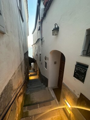 Eine schmale Gasse mit einer Treppe, die zu einem Hauseingang führt.