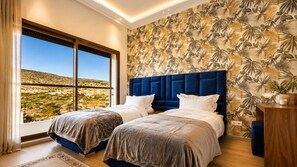 A bedroom with two beds, a large window, and a tropical wallpaper. - Exclusive-use villa with private chef and heated pool, above Taghazout Bay (Taghazout Bay)