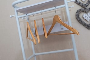 Un perchero de metal con perchas de madera.