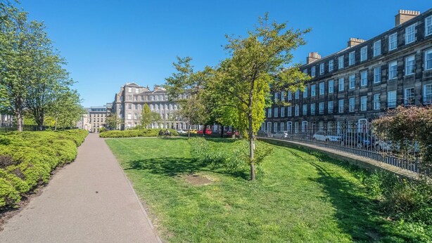 A pathway leading to a building with a traditional architectural style, surrounded by well-maintained greenery and a clear blue sky. - Cosy 2 Bed in Central Edinburgh - Pass the Keys (Edinburgh)