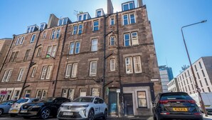 A multi-story building with a brick facade, multiple windows, and a door. - Cosy 2 Bed in Central Edinburgh - Pass the Keys (Edinburgh)