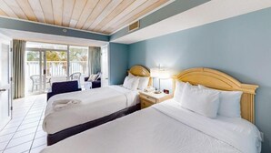 A hotel room with two beds, a wooden ceiling, a blue wall, and a balcony with outdoor furniture. - Camelot by the Sea: resort in beautiful Myrtle Beach. Fitness room, pool & beach (Myrtle Beach)