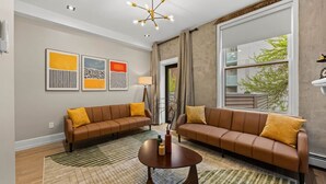 A modern living room with two sofas, a coffee table, and abstract art on the wall.