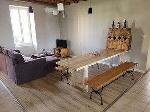 Ein modernes Wohnzimmer mit einem Holzesstisch, einer Bank und einem Sofa.