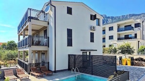 A modern building with a pool, balconies, and a mountain view. - #3 Holiday Apartment MTG - Orebić (Orebić)