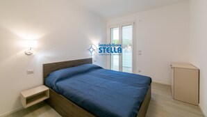 Ein Schlafzimmer mit einem Bett, einem Nachttisch und einem kleinen Schrank.
