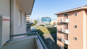 En bostadsbyggnad med balkonger, en klar himmel och en skylt med texten ”immobiliare STELLA”.