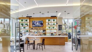 Un espace bar avec un comptoir en bois, des sièges et un écran de télévision.