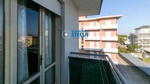 A building with a sign reading 'immobiliare STELLA' and a balcony with a metal railing. - Romeo # three-room apartment 19# with beach space° (Lido di Jesolo)