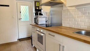 Eine kompakte Küche mit Mikrowelle, Herd und einem eingebauten Backofen.