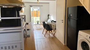 Eine kleine Küche mit Waschmaschine, Mikrowelle und Kühlschrank.