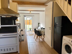 Une cuisine compacte équipée d’un lave-linge, d’un four à micro-ondes et d’un réfrigérateur.