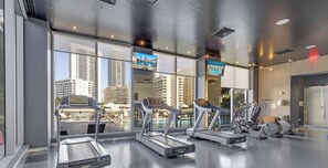 Ein Fitnessstudio mit Laufbändern, Ergometer und Gewichten.