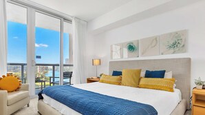 Une chambre d’hôtel avec un grand lit, une vue sur la ville et un balcon.