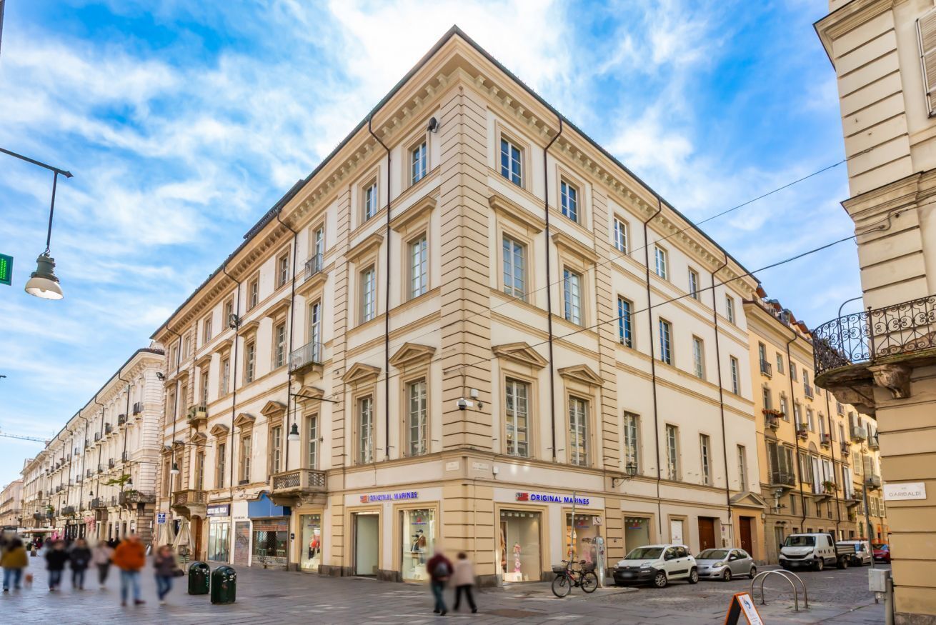 A historic building with multiple stories, large windows, and a prominent corner entrance.