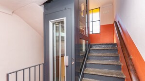 Una escalera con una puerta de cristal que da a una habitación.