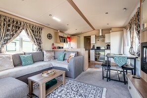 A compact living space with a sofa, a dining table, and a kitchenette. - St Andrews Holiday Park | Harbour Reach (No 11) (St Andrews)