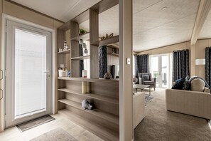 Ein modernes Wohnzimmer mit einer Couch, einem Couchtisch und einer Treppe mit integrierten Regalen.