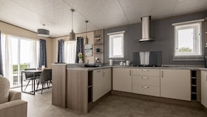 A modern kitchen with a central island, built-in cabinets, and pendant lighting. - Lodge No 138 | Stewarts Resort Cameron (Cameron)